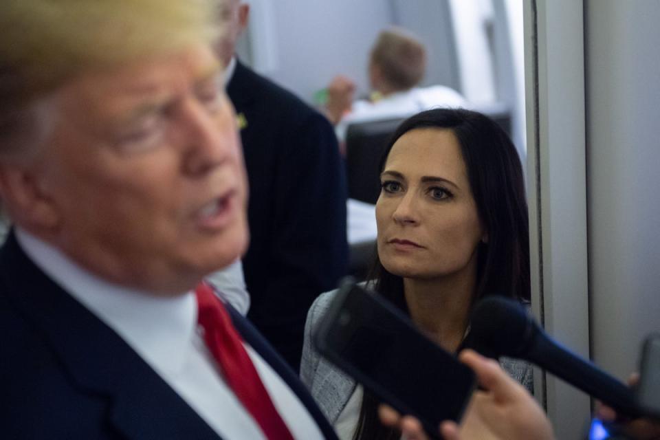 White House Press Secretary Stephanie Grisham listens as US President Donald Trump speaks to the media aboard Air Force One in 2019 (AFP via Getty Images)