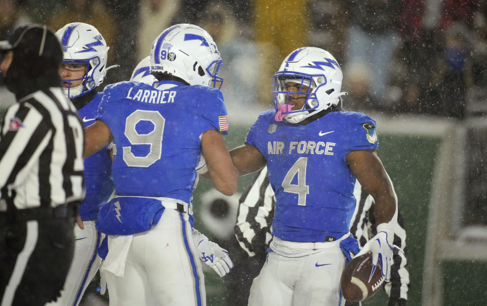 Air Force quarterback Zac Larrier (9) congratulates fullback Emmanuel Michel (4) after Michel's touchdown run in the second half of an NCAA college football game against Colorado State, Saturday, Oct. 28, 2023, in Fort Collins, Colo. (AP Photo/David Zalubowski)