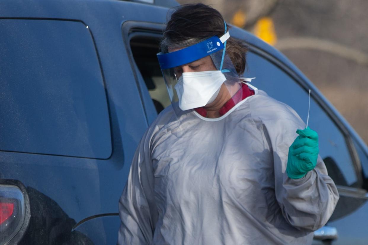 Jen Collins, registered nurse at Holton Community Hospital, helps administer COVID-19 tests to vehicles pulling into the testing site on a December morning.