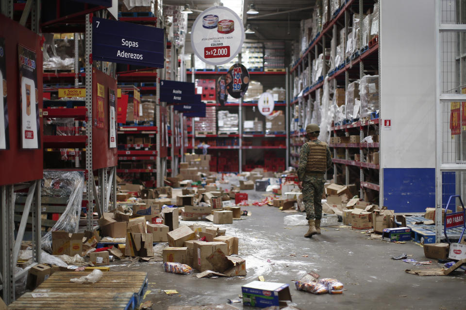 A soldier walks inside a looted supermarket in Santiago, Chile, Tuesday, Oct. 22, 2019. Chile has been facing days of unrest, triggered by a relatively minor increase in subway fares. The protests have shaken a nation noted for economic stability over the past decades, which has seen steadily declining poverty despite persistent high rates of inequality. (AP Photo/Luis Hidalgo)