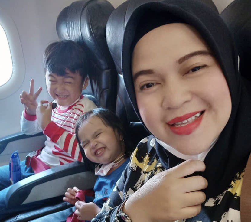 Ratih Windania pictured on board a flight with two children.