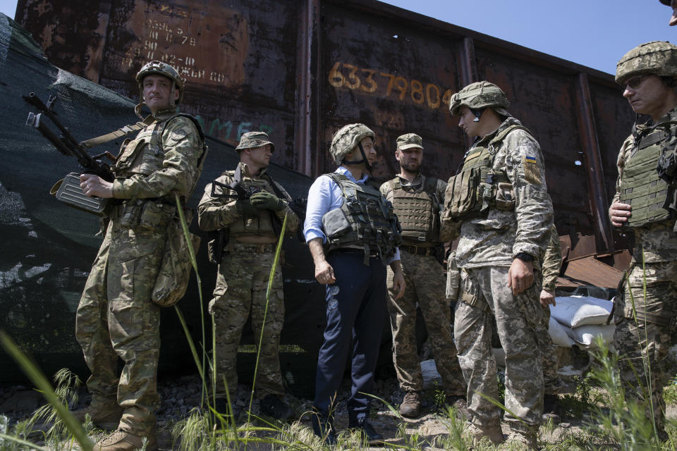 Ukrainian President Volodymyr Zelenskiy, center, talks with servicemen as he visits the war-hit Luhansk region, eastern Ukraine, Monday, May 27, 2019. (Ukrainian Presidential Press Office via AP)