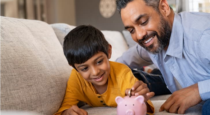 Image shows a parent and child putting money in a piggy bank together. Children may be beneficiaries in a generational wealth transfer.