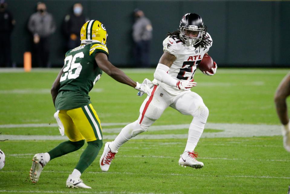 Atlanta Falcons' Todd Gurley (21) runs against Green Bay Packers' Darnell Savage (26) during the second half of an NFL football game, Monday, Oct. 5, 2020, in Green Bay, Wis. (AP Photo/Mike Roemer)