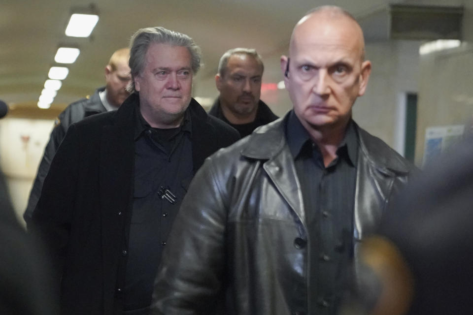 Steve Bannon, left, is surrounded by security as he arrives at Manhattan Supreme Court, Tuesday, Feb. 28, 2023, in New York. Bannon is accused of fraud in connection with a charity raising money for a wall on the southern U.S. border. (AP Photo/Mary Altaffer)