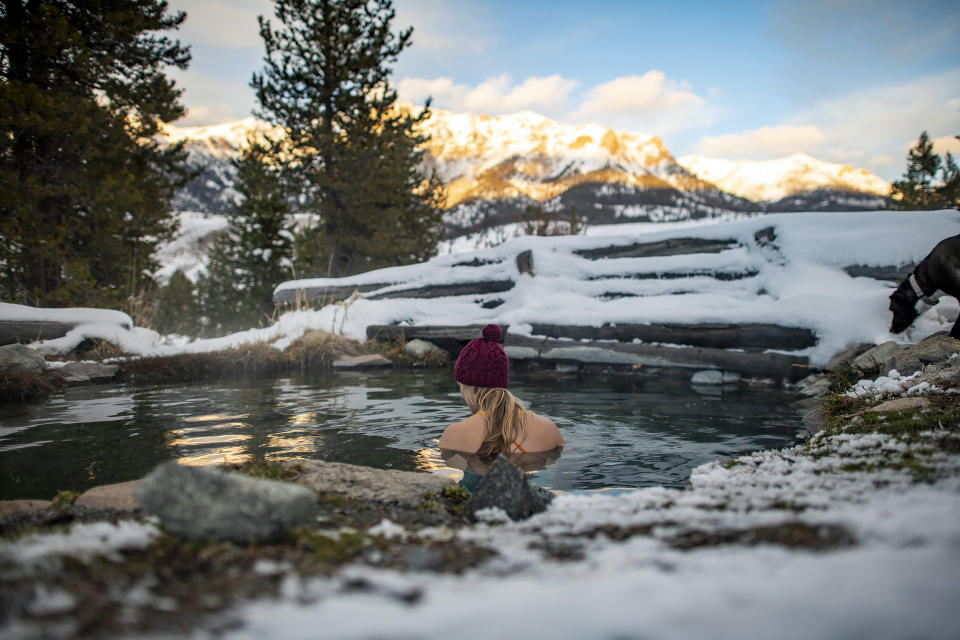 A woman enjoying an evening sunset in a hot spring. (Getty Images)