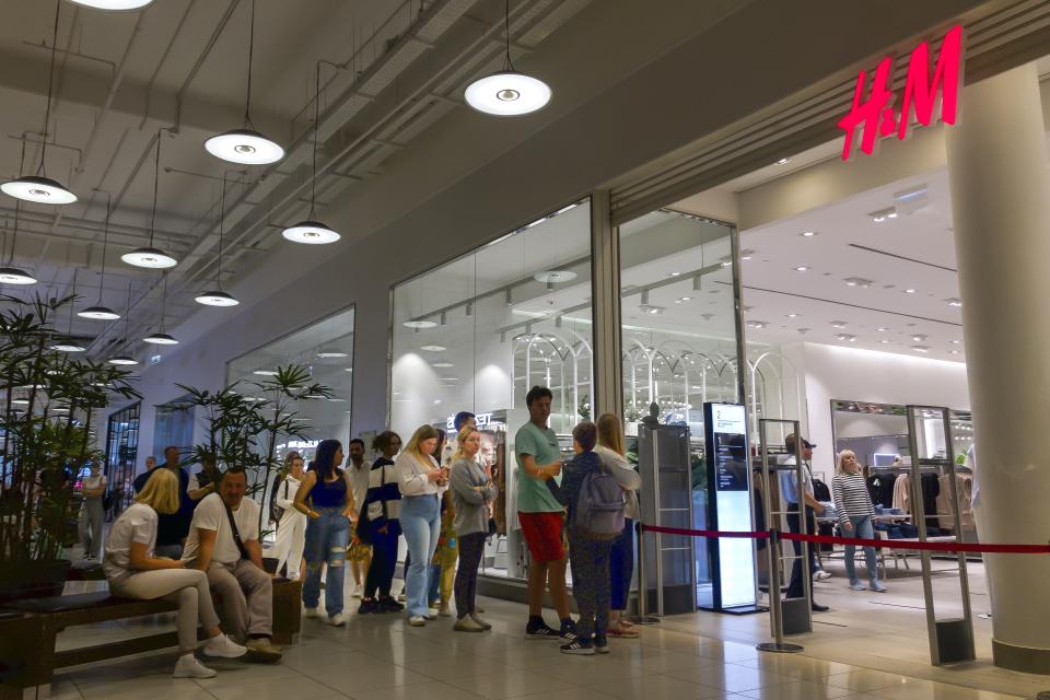 FILE - People line up to enter an H&M shop and buy items on sale in the Aviapark shopping mall in Moscow, Russia, on Aug. 9, 2022. Russians are snapping up While 191 foreign companies have left Russia and 1,169 are working to do so, some 1,223 are staying and 496 are taking a wait-and-see approach, according to a database compiled by the Kyiv School of Economics. (AP Photo/Alexander Zemlianichenko, File)