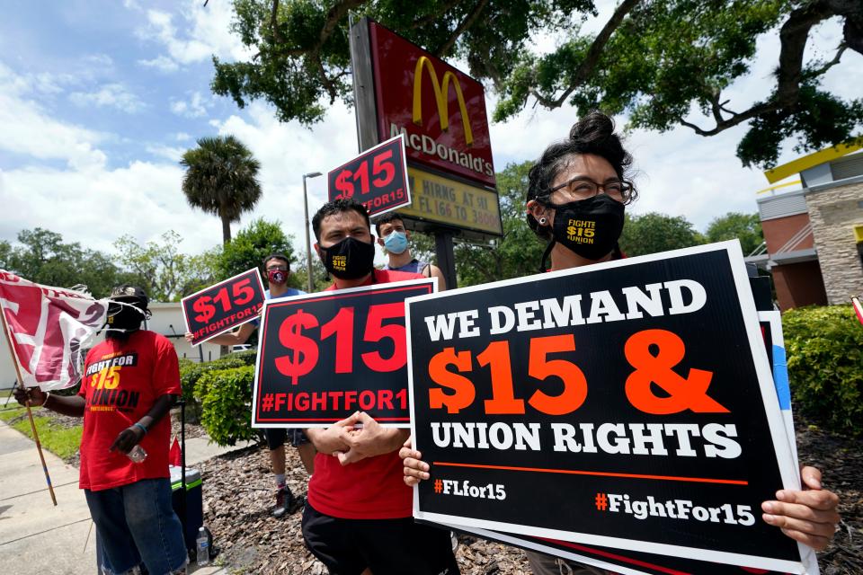 Workers and family members take part in a 15-city walkout to demand $15 an hour wages on May 19, 2021, in front of a McDonald's restaurant in Sanford, Fla.