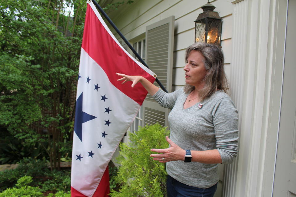 Laurin Stennis, an artist, speaks outside her home in Jackson, Miss., on Wednesday, April 17, 2019, and explains how she thinks a flag she designed, which flies next to her, would be an appropriate symbol to replace the state flag that Mississippi has used since 1894. The current flag includes the Confederate battle emblem, and Stennis's design does not. Mississippi Gov. Phil Bryant has signed a bill that authorizes several new specialty license plates, including one featuring the "Stennis flag." (AP Photo/Emily Wagster Pettus)