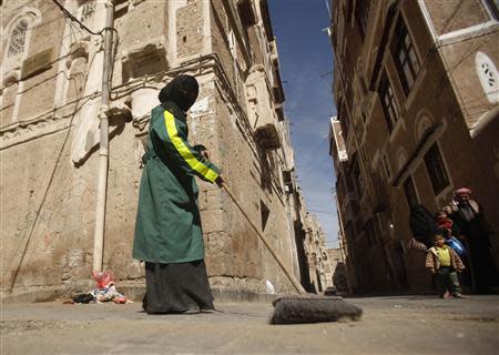 A female worker cleans a street in Old Sanaa city November 11, 2013. REUTERS/Khaled Abdullah