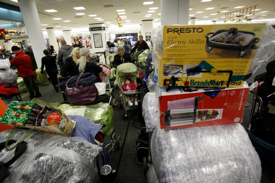 FILE - In this Dec. 16, 2010 FILE photo, carts are loaded with luggage as passengers wait in line for a flight to Cuba at Miami International Airport in Miami, ahead of the Christmas holiday. State-run stores that sell low-quality Chinese household goods at double or triple their price are facing competition from vendors in locations where Cubans fly, fill suitcases with goods, and return to sell them at a profit. (AP Photo/Lynne Sladky, File)