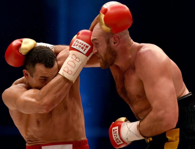 Wladimir Klitschko (L) tries to defend himself against Tyson Fury during their WBA, IBF, WBO and IBO title bout in Duesseldorf, western Germany, on November 28, 2015