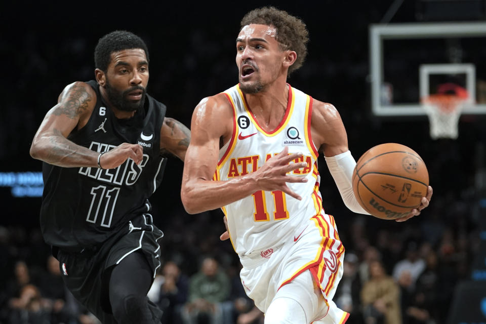 Atlanta Hawks guard Trae Young, right, drives against Brooklyn Nets guard Kyrie Irving during the first half of an NBA basketball game Friday, Dec. 9, 2022, in New York. (AP Photo/Mary Altaffer)
