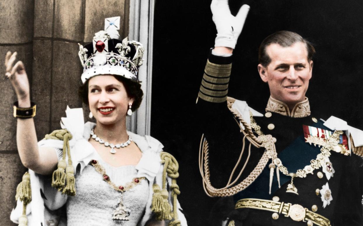 Queen Elizabeth and the Duke of Edinburgh wave to the crowd from the Buckingham Palace balcony on the day of their coronation