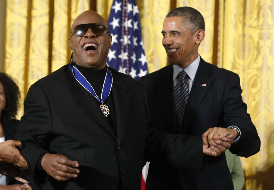 Singer Stevie Wonder (L) is congratulated by U.S. President Barack Obama after receiving the Presidential Medal of Freedom during a White House ceremony in Washington, November 24, 2014. The Presidential Medal of Freedom is the Nation's highest civilian honor, presented to individuals who have made especially meritorious contributions to the security or national interests of the United States, to world peace, or to cultural or other significant public or private endeavors. REUTERS/Larry Downing (UNITED STATES  - Tags: POLITICS ENTERTAINMENT SOCIETY)  