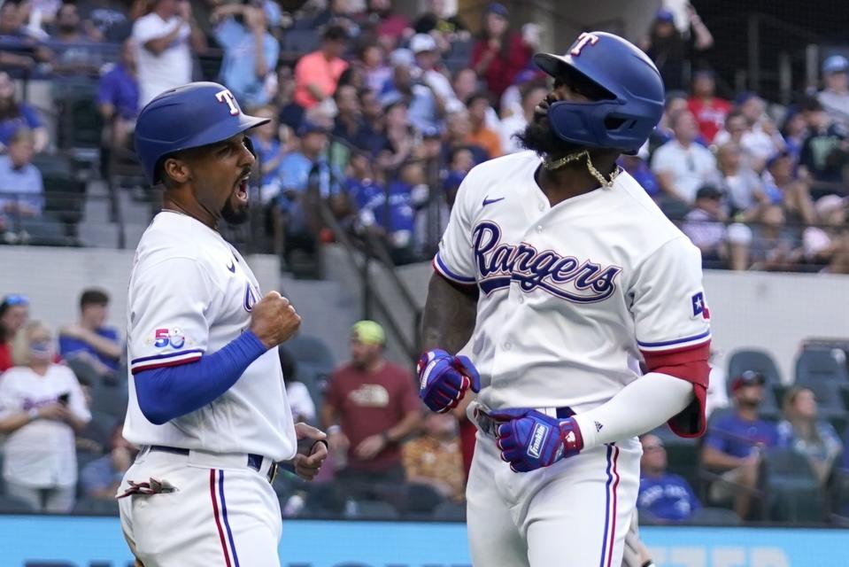 Texas Rangers' Marcus Semien, left, and Adolis Garcia celebrate after Garcia hit a three-run home run during the first inning of the team's baseball game against the Toronto Blue Jays in Arlington, Texas, Saturday, Sept. 10, 2022. (AP Photo/Tony Gutierrez)