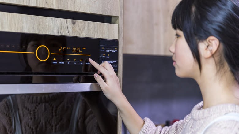 woman adjusting oven timer