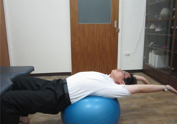 【頸胸腰伸展運動】可仰躺於瑜珈球上，將脊椎往後伸展後放鬆仰於球上30秒至1分鐘。（圖片／美國脊骨神經醫學博士張軒彬提供）
