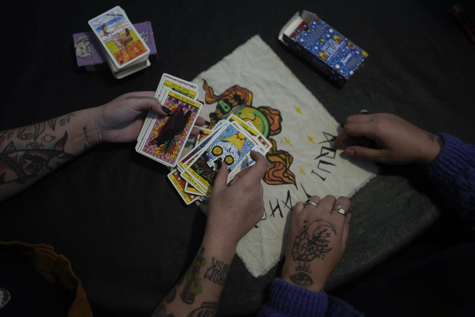 Aldana Mendez holds a set of tarot cards, accompanied by Ana Ottobre, in Villa Carlos Paz, Argentina, Wednesday, July 19, 2023. Both women who identify as spiritual but not religious, feel that tarot guides their life. In the pope’s homeland of Argentina, Catholics have been renouncing the faith and joining the growing ranks of the religiously unaffiliated. Commonly known as the “nones,” they describe themselves as atheists, agnostics, spiritual but not religious, or simply: “nothing in particular.” (AP Photo/Natacha Pisarenko)