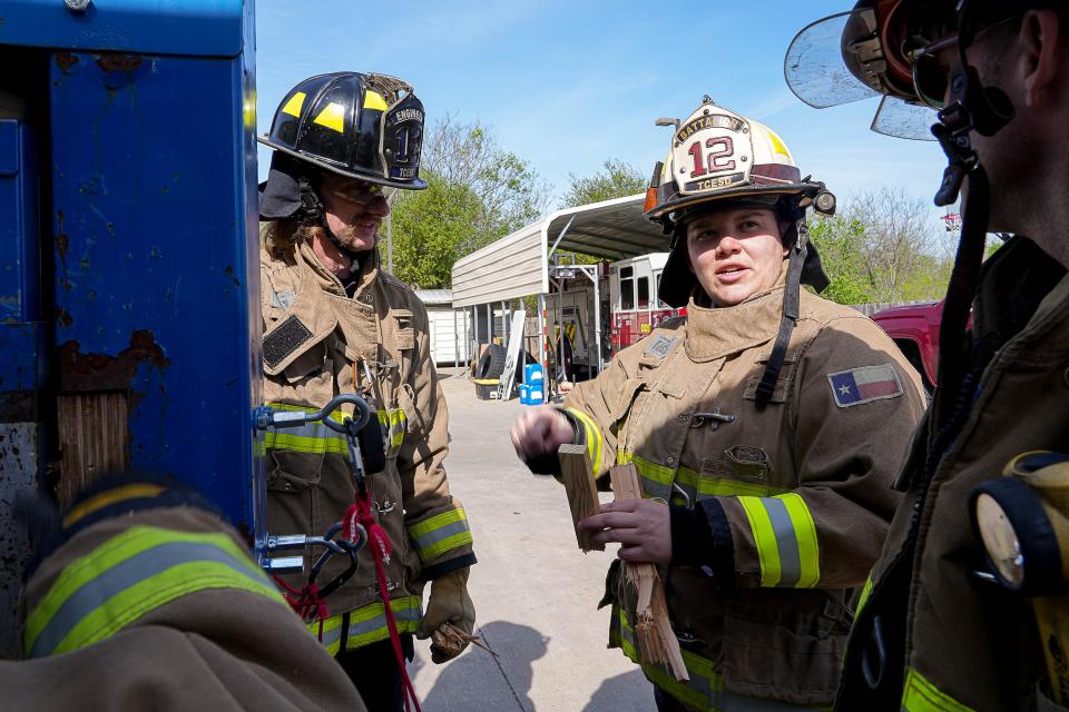 Ashley Brackett, battalion chief for Travis County Emergency Services District No. 12, talks to her team during forcible entry training March 18 in Manor. Brackett put in the time and effort to prove to the male firefighters that she is "more than capable of keeping them safe on a fireground."