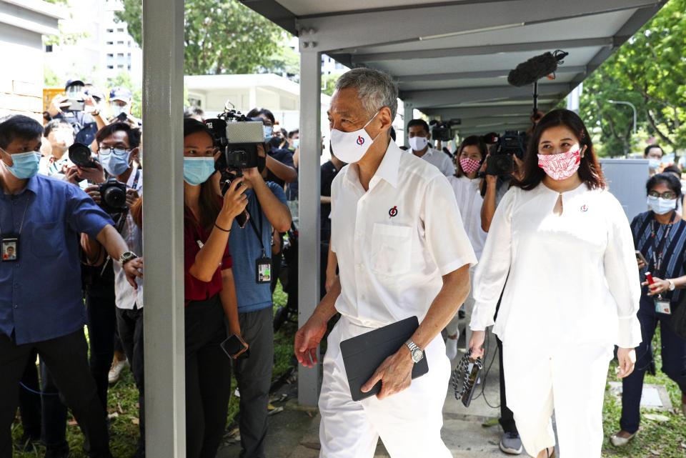 People's Action Party Secretary-General and Singaporean Prime Minister Lee Hsien Loong, center, arrives at a nomination center with his team to submit their nomination papers ahead of the general election in Singapore, Tuesday, June 30, 2020. Campaigning began Tuesday for Singapore's general elections, with the opposition hoping to dent the ruling party's supermajority in parliament with support from Prime Minister Lee's estranged younger brother.(AP Photo/Yong Teck Lim)