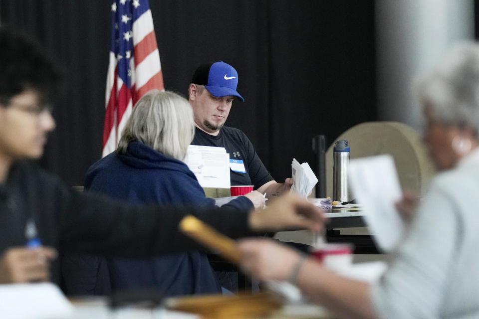Election workers sort through absentee ballots, Tuesday, Feb. 27, 2024, in Warren, Mich. (AP Photo/Carlos Osorio)