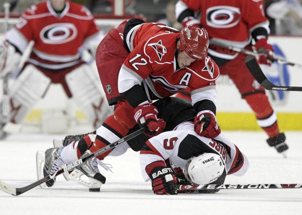 The Carolina Hurricanes’ Eric Staal (12) rides the New Jersey Devils’ Zach Parise (9) to the ice as they go for the puck during first period action of Game 6 of an NHL playoff between the Carolina Hurricanes and the New Jersey Devils at the RBC Center in Raleigh NC on Sunday April 26, 2009.