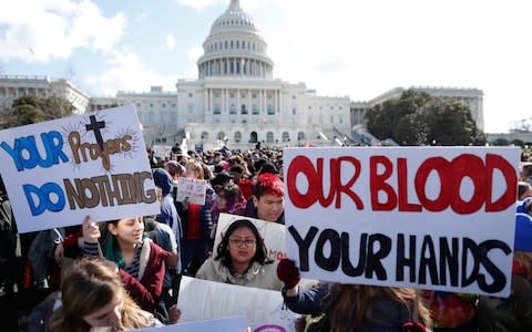 Students gather outside the U.S. Capitol during walk-outs in support of stricter gun laws in Washington - Credit:  REUTERS
