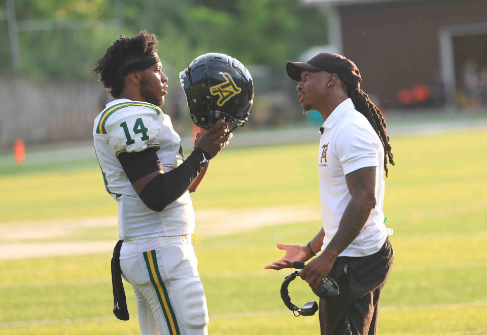 Taft head coach Tyler Williams talks with starting quarterback Javier Ison during their game against Roger Bacon Thursday, Aug. 18, 2022.