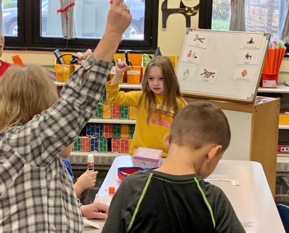 Lexington Elementary kindergarten Ashton Zickefoose and classroom aide Debbie Schmucker punch the air to emphasize the letter sound of a word as part of a literacy assignment in teacher Mary Beth DelCalzo's classroom.