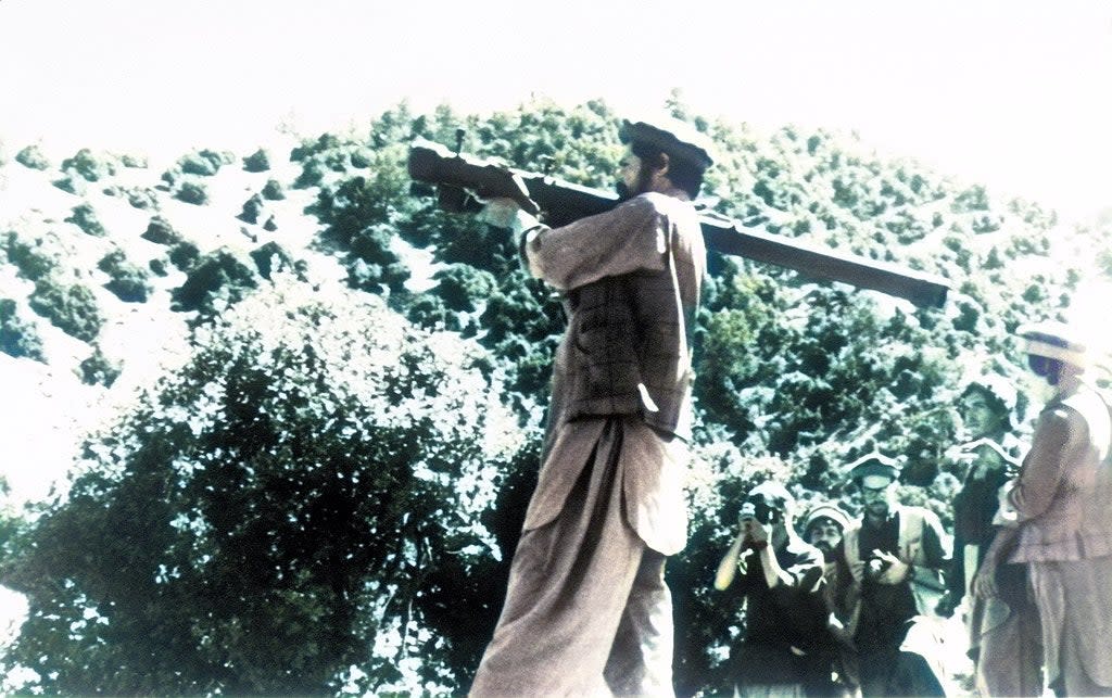 a member of the Mujahideen carries a weapon on his soldier