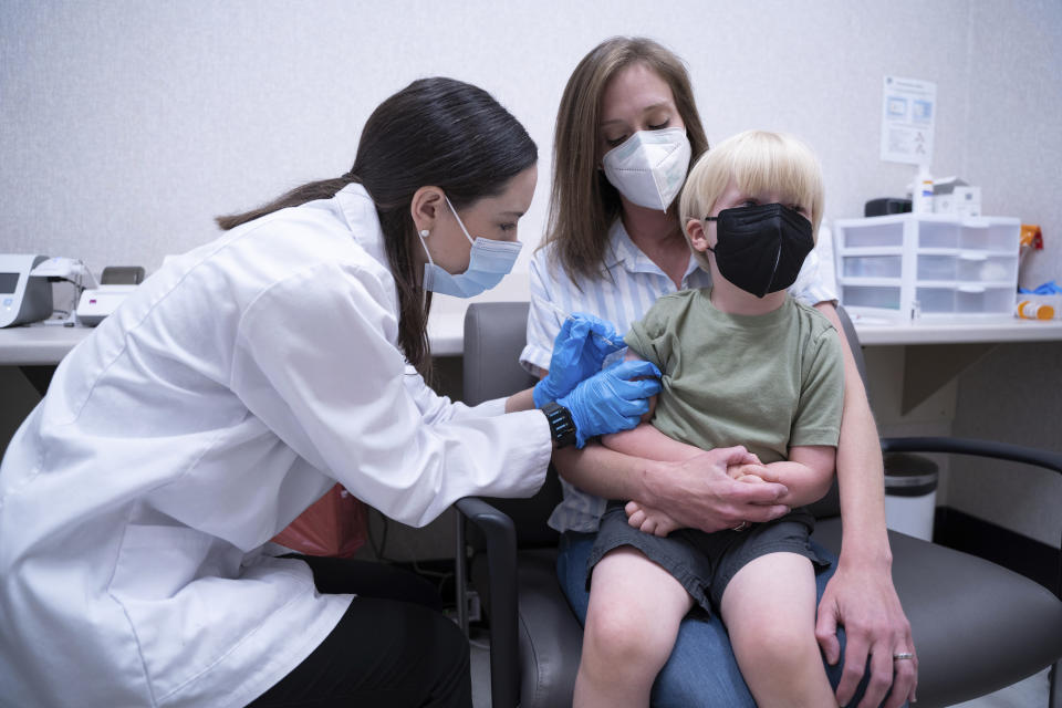 Pharmacist Kaitlin Harring, left, administers a Moderna COVID-19 vaccination to three year-old Fletcher Pack, while he sits on the lap of his mother, McKenzie Pack, at Walgreens pharmacy Monday, June 20, 2022, in Lexington, S.C. Today marked the first day COVID-19 vaccinations were made available to children under 5 in the United States. (AP Photo/Sean Rayford)