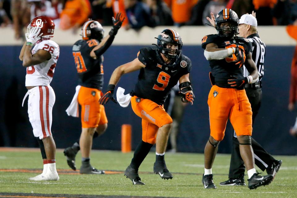 OSU's Brock Martin (9) and Collin Oliver (30) celebrate beside OU's Kennedy Brooks (26) after sacking Caleb Williams in the final minute of a 37-33 win last season in Stillwater.