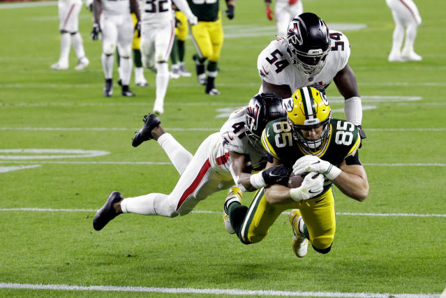 Green Bay Packers' Robert Tonyan (85) goes in for a touchdown as he is tackled by Atlanta Falcons' Sharrod Neasman (41) and Foye Oluokun (54). (AP Photo/Mike Roemer)