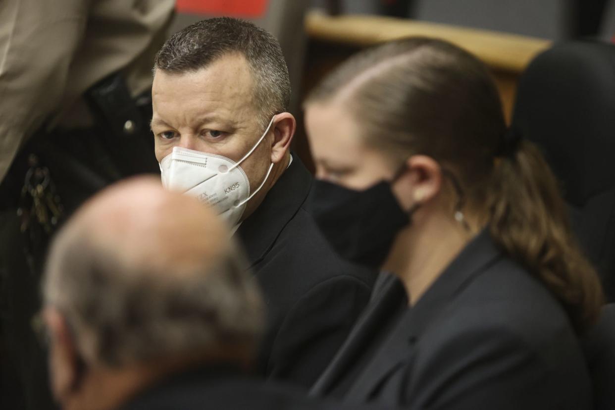 Paul Flores talks to his attorneys Sara Sanger and Robert Sanger on Wednesday in San Luis Obispo, Calif. 