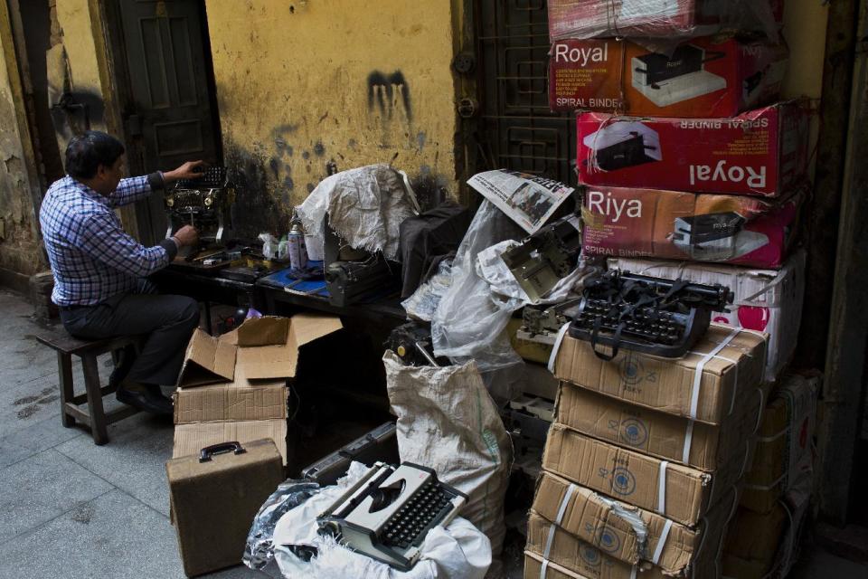 In this Jan. 16, 2017 photo, an Indian laborer repairs an old typewriter in New Delhi, India. India still has a few thousand remaining professional typists. There are a handful of typewriter repairmen and stores selling spare parts. There are typing schools that, at least occasionally, are jammed with students. But even in this country, one of the last places in the world where the typewriter remains a part of everyday life, the end is, finally, coming. (AP Photo/Bernat Armangue)