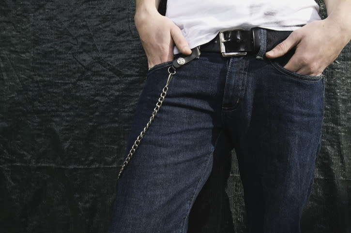 Person in jeans with a chain attached to the belt loop, hands at waist, close-up of lower torso