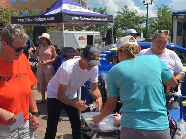 Pro skateboarder Bucky Lasek, center-left, gives an autograph to a fan at the Innoskate festival in Sioux Falls, South Dakota on Friday, July 8, 2022. The Baltimore skater visited the state to the surprise of many attendees while representing his rallycross race team under Subaru.