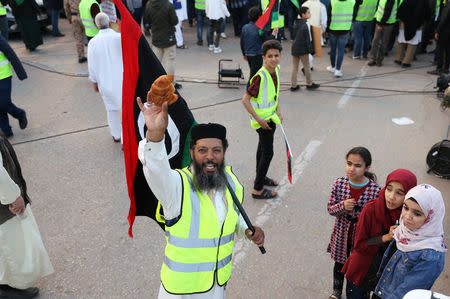 A Libyan protester holds a croissant (La Brioche) as he attends a demonstration to demand an end to the Khalifa Haftar's offensive against Tripoli, in Martyrs Square in central Tripoli, Libya April 19, 2019. REUTERS/Ahmed Jadallah