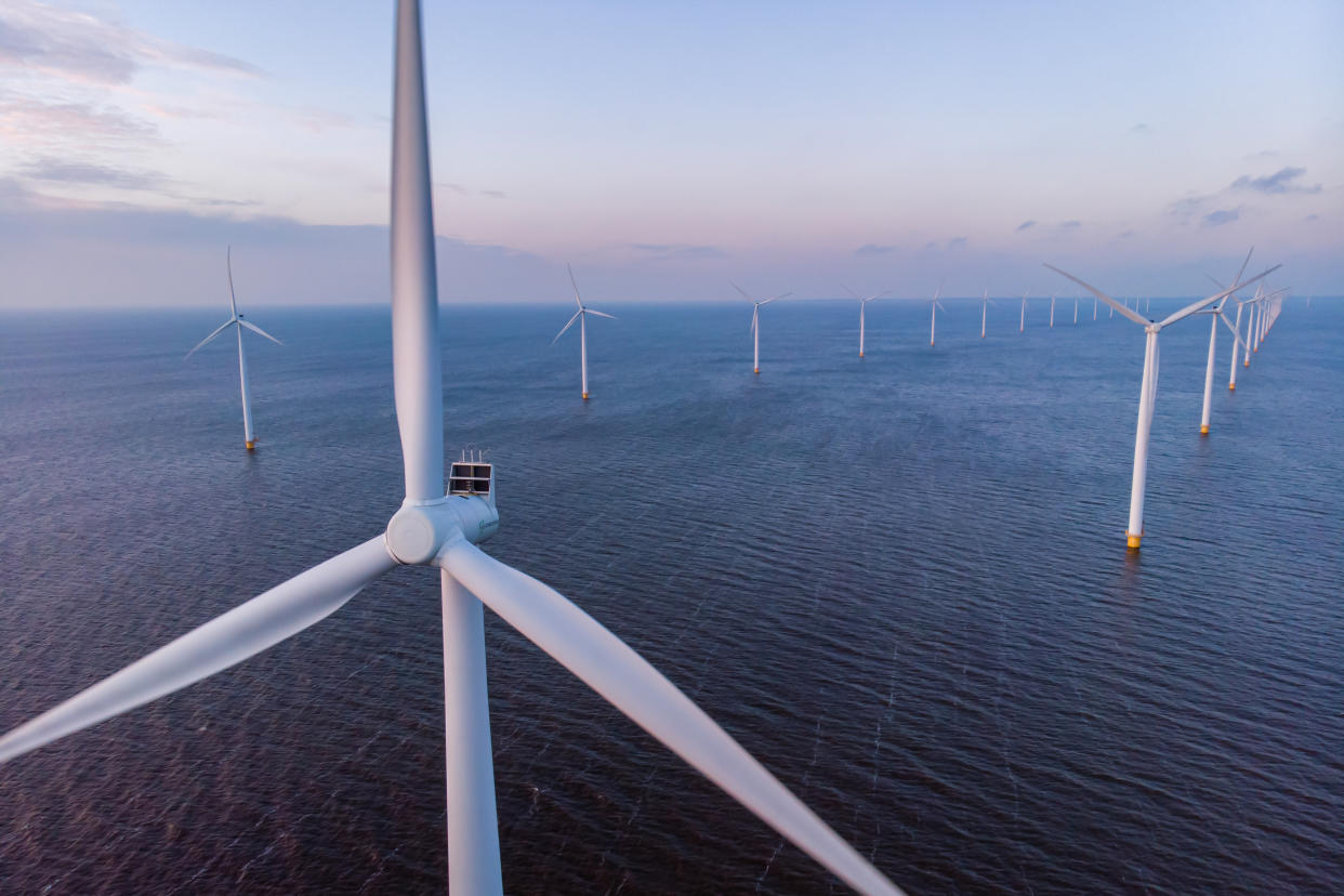Windmill park green energy during sunset in the ocean, offshore wind mill turbines Netherlands