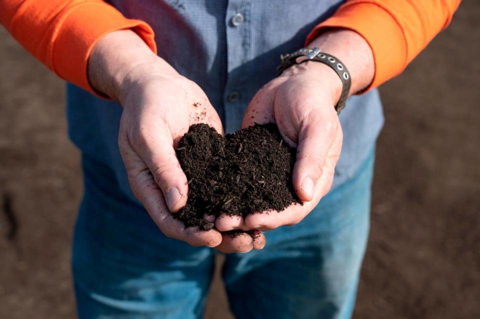 Facility supervisor Nathan Gorth holds finished compost at the City of Modesto Compost Facility west of Modesto, Calif., on Wednesday, Nov. 17, 2021.