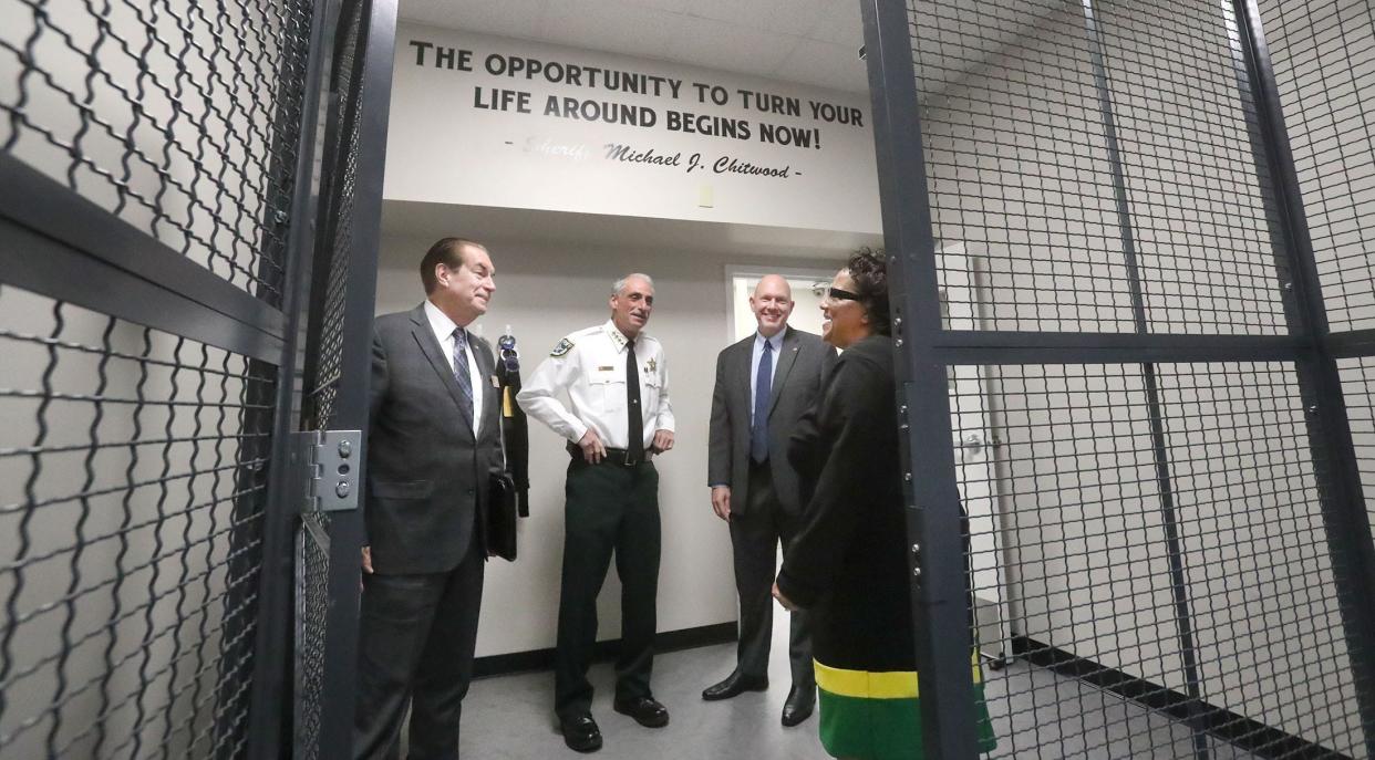 Florida State Sen. Tom Wright, Volusia County Sheriff Mike Chitwood, Department of Juvenile Justice Secretary Eric Hall, and VCSO Juvenile Services Director Carla Quann look over one of the holding cells, Thursday, Nov. 17, 2022, at the Volusia Family Resource Center with a message on the wall to juvenile offenders from the sheriff.