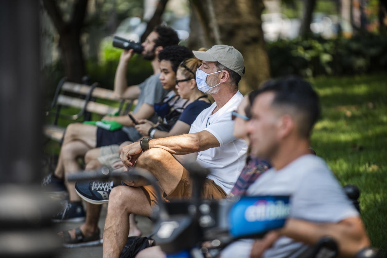 Gente en las bancas del parque Washington Square en Nueva York, el 27 de julio de 2021. (Brittainy Newman/The New York Times).