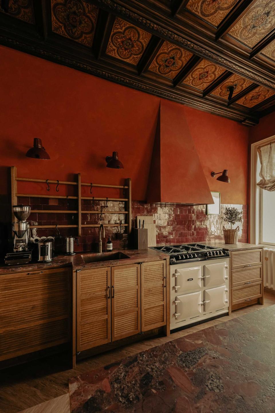 a kitchen with red walls and red marble countertops