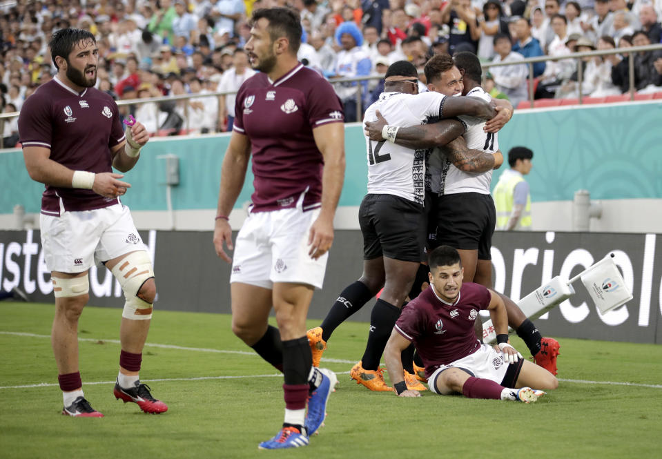 Fiji's Semi Radradra, right, is congratulated by teammates after scoring a try during the Rugby World Cup Pool D game at Hanazono Rugby Stadium between Georgia and Fiji in Osaka, Japan, Thursday, Oct. 3, 2019.Fiji defeated Georgia 45-10. (AP Photo/Jae C. Hong)