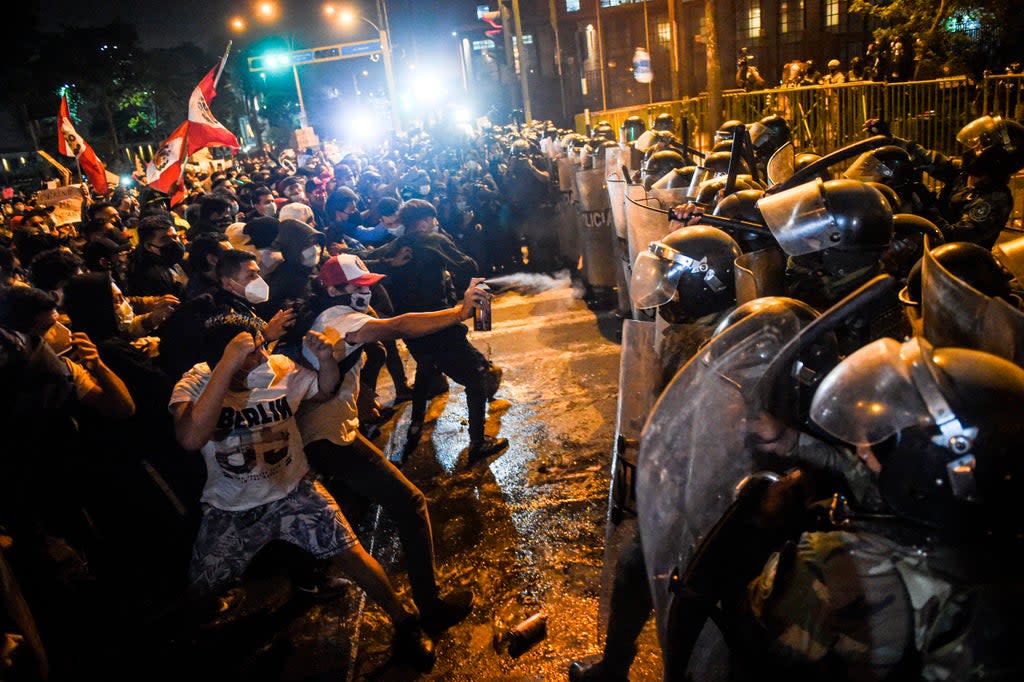 Demonstrators confront riot police during a protest against the new government  (AFP via Getty Images)