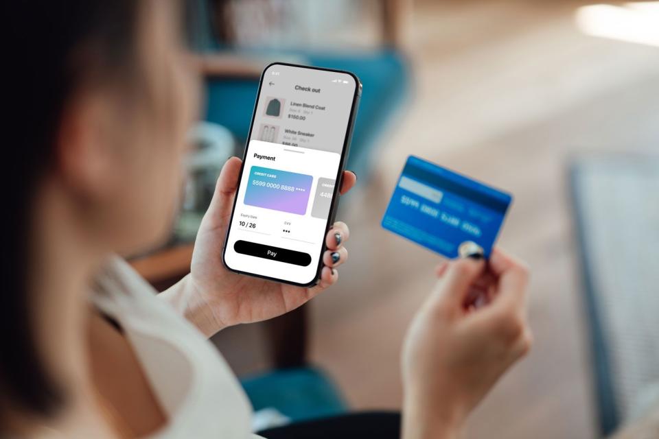 <p>Getty</p> Stock image of woman looking at her bank card and online banking account