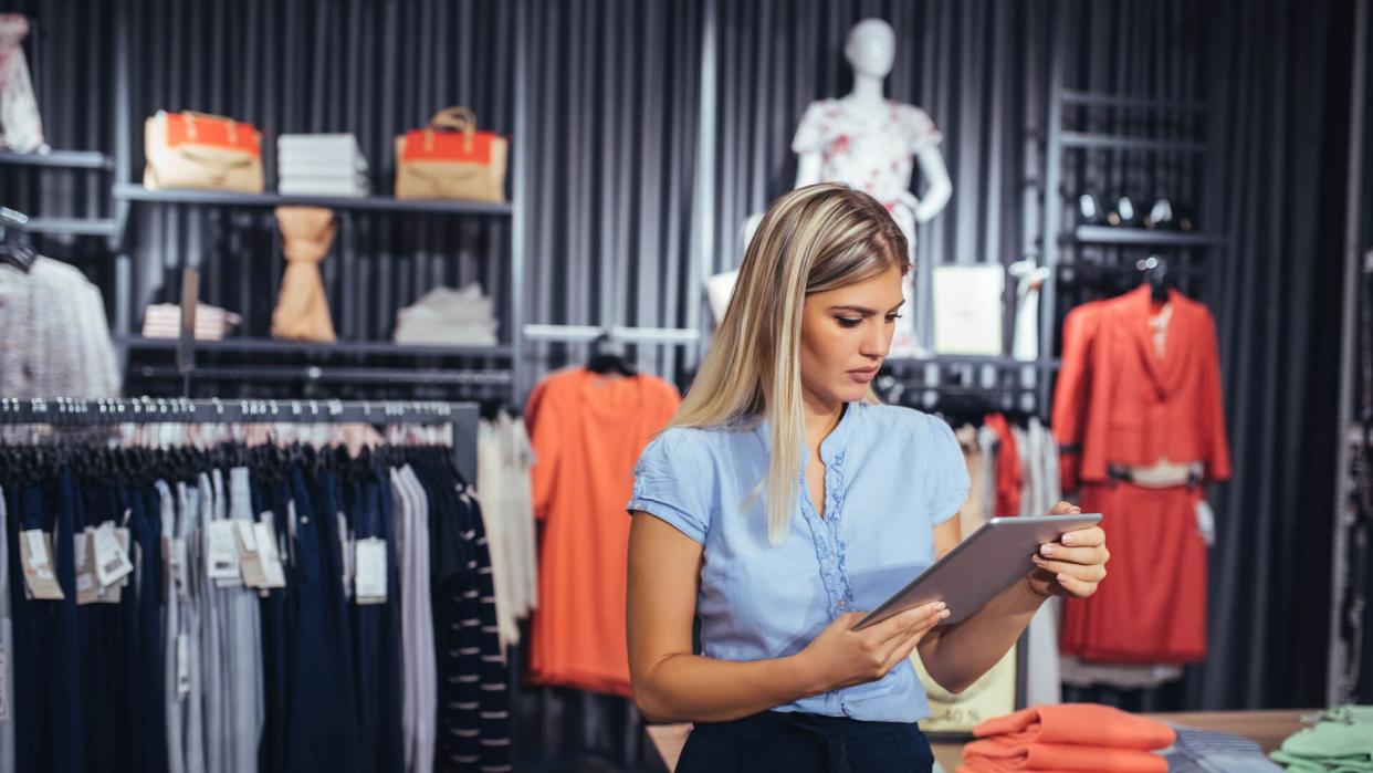 Portrait of a young woman using digital tablet in the store.