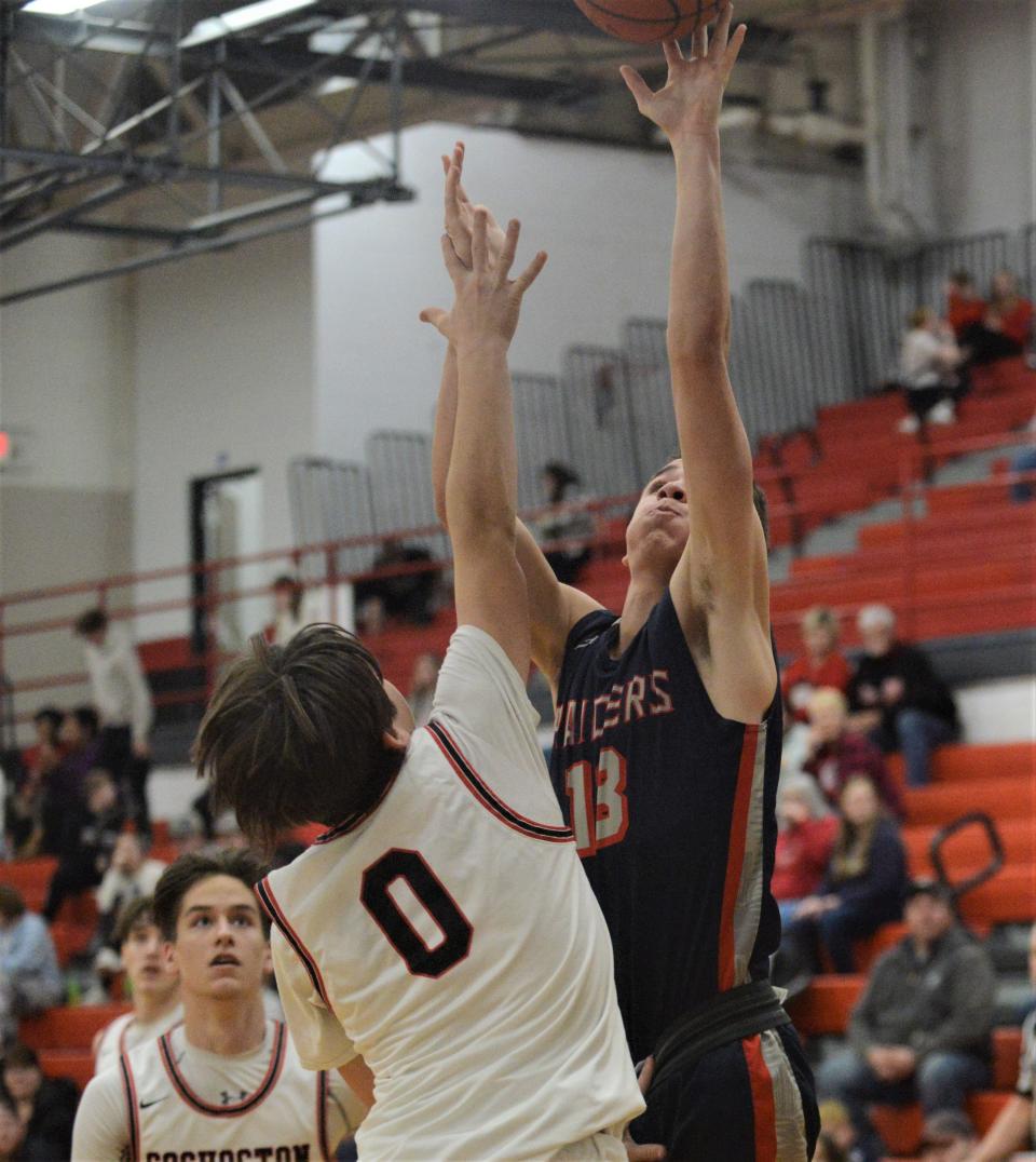 Morgan's Quintin Davis puts up a shot over Coshocton's Bentley Cunningham during Friday's game. The Raiders won 83-68.