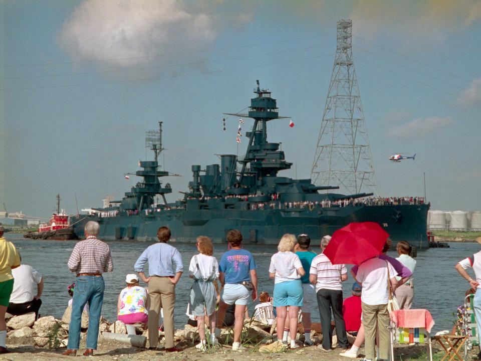 People on coast watching USS Texas return to port